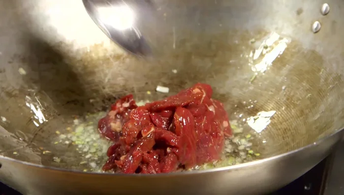 Aggiungere la carne marinata al wok e cuocere a fuoco vivace per circa 3 minuti, fino a doratura.
