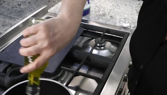 In una padella, aggiungere olio extravergine d'oliva e uno spicchio d'aglio.