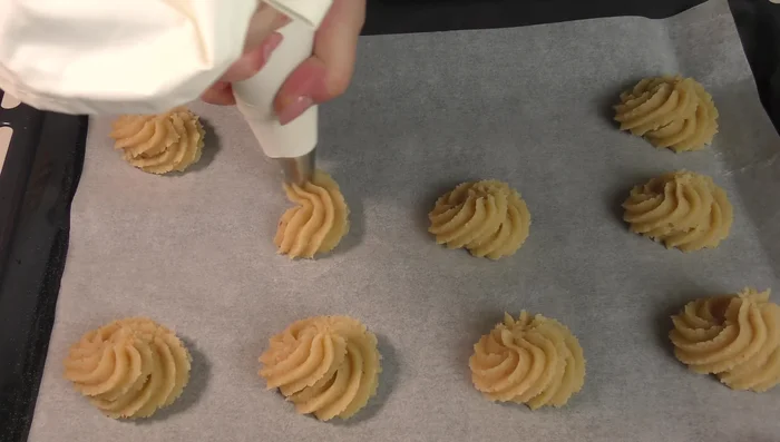 Realizzare i pasticcini su una teglia rivestita di carta forno, distanziandoli leggermente tra di loro.