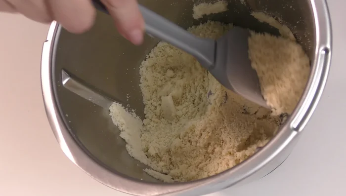 Versare la farina di mandorle in una ciotola capiente insieme a 300 g di zucchero a velo.