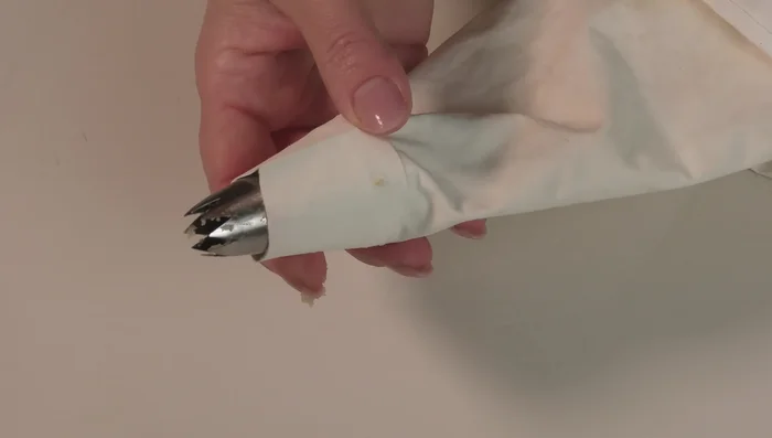 Trasferire il composto in una sac à poche di tela con bocchetta a stella. (Sconsigliato l'utilizzo di sac à poche usa e getta).