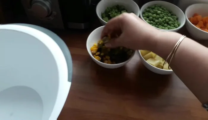 Preparare l'insalata: unire patate lesse, mais, olive nere e verdi, cetrioli sottaceto, broccoli lessi, carote, cipolla, prezzemolo, sale, olio d'oliva, cumino, pepe e aceto. Mescolare.
