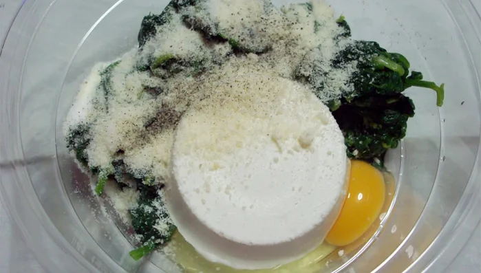 In una terrina, mettete la ricotta, gli spinaci raffreddati, le uova, il parmigiano, il sale e il pepe. Amalgamate bene tutti gli ingredienti.