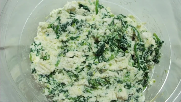 Foderate una teglia con carta forno. Stendete la prima sfoglia di pasta.