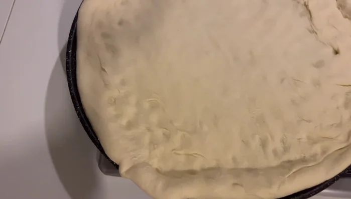 Aggiungere il ragù sulla base di pizza.