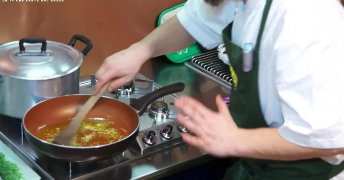 Aggiungere l'aglio tritato e soffriggere a fuoco molto basso, senza far prendere colore all'aglio.