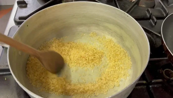 Cuocere il riso. Dopo averlo tostato, aggiungere due mestoli d'acqua e un po' di prezzemolo. Continuare ad aggiungere acqua fino al dodicesimo minuto di cottura.