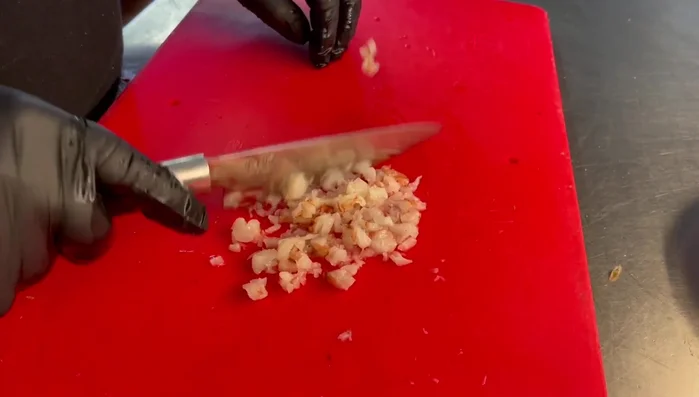 Marinare i gamberoni tritati con sale, prezzemolo e olio extravergine d'oliva. Coprire con pellicola e lasciare riposare per 15-20 minuti.