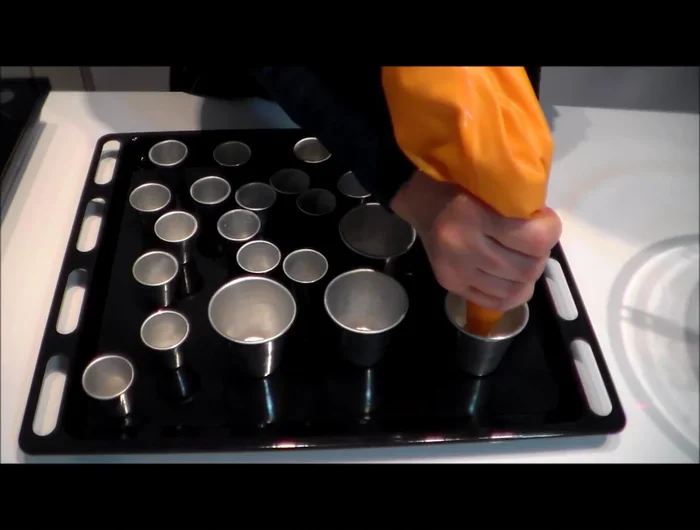 Riempire le formine per babà con l'impasto (circa a metà o tre quarti), utilizzando una sac à poche. Lasciare lievitare di nuovo per la seconda lievitazione a 30°C.