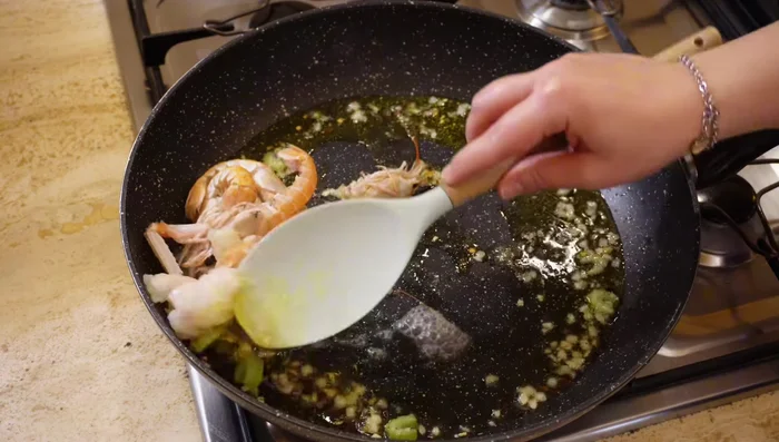 Aggiungere gli scampi puliti (sia interi che a pezzi) e farli rosolare leggermente.
