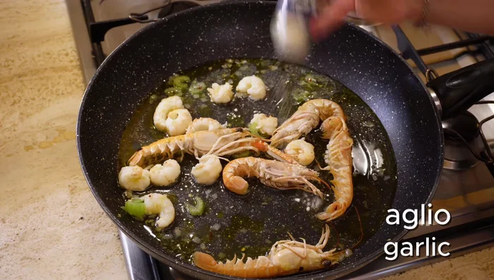 Unire un po' d'acqua, l'aglio in polvere, il pepe nero e il sale. Coprire e lasciar cuocere fino a quando gli scampi saranno cotti.