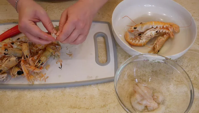 Scongelare e pulire gli scampi, rimuovendo il budello. Tenere da parte alcuni scampi interi per la decorazione.