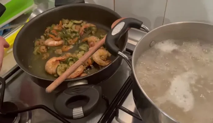 Scolare la pasta e mantecarla nel sugo di gamberi e zucchine, aggiungendo un po' di acqua di cottura.