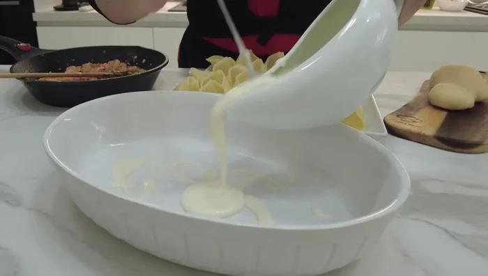 Ungere una teglia da forno, distribuire un po' di besciamella sul fondo, disporre i conchiglioni ripieni, aggiungere un pezzo di provola affumicata su ogni conchiglione.