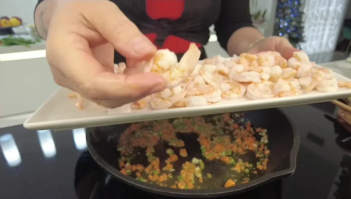 Aggiungere i gamberoni puliti e sgusciati (freschi o congelati) e cuocere per un minuto.