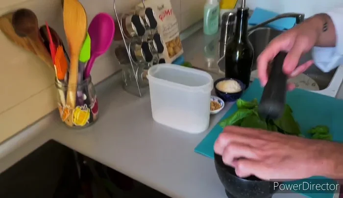 Aggiungere le foglie di basilico al mortaio, un po' alla volta, pestando delicatamente.