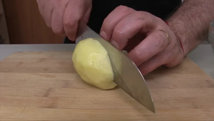 Pelare le patate, metterle in acqua fredda per evitare l'ossidazione, tagliarle a spicchi e rimetterle in acqua fredda per eliminare l'amido.