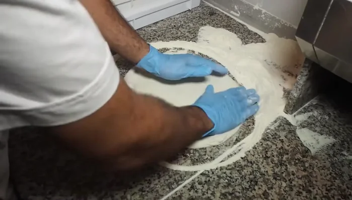 Stendere l'impasto per pizza.
