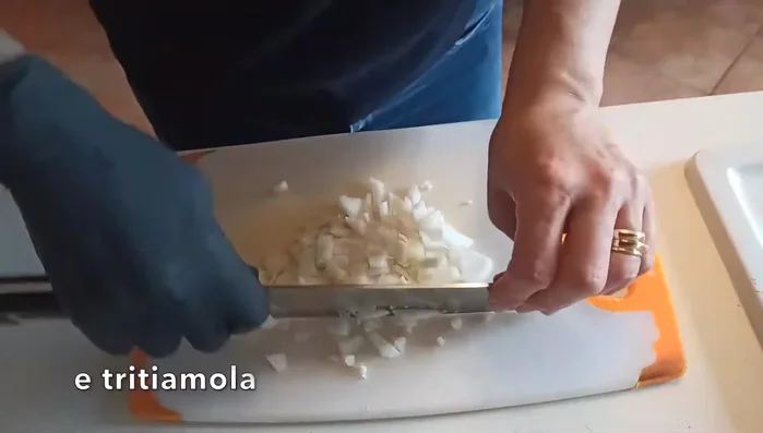 Tritare finemente la cipolla e il prezzemolo.