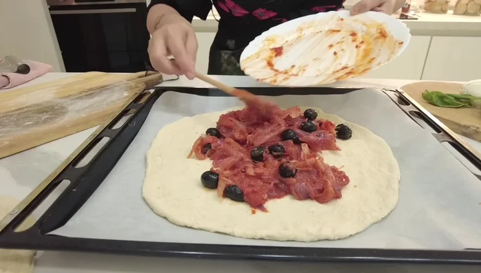 Aggiungete la farcia di cipolle, pomodoro, olive e basilico. Aggiungete le acciughe, creando un ripieno simile allo sfincione palermitano.
