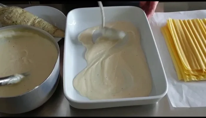 Stendere la besciamella sul fondo di una teglia. Riempire i cannelloni con il composto di pesce usando un sacco da pasticceria.