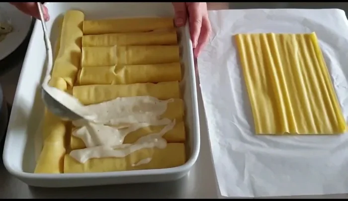Coprire i cannelloni con abbondante besciamella, prezzemolo e, facoltativamente, parmigiano grattugiato.