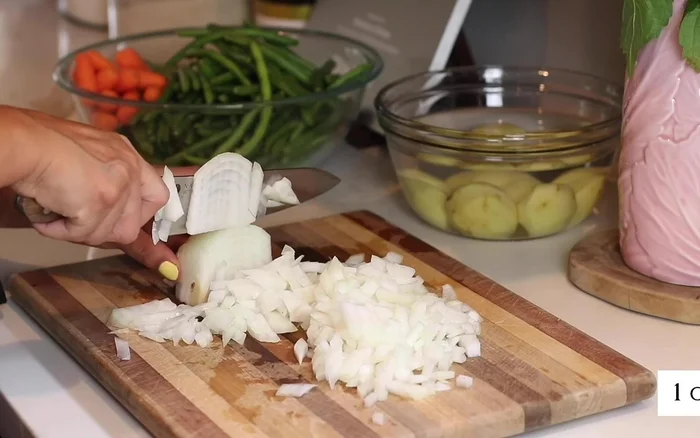 Trasferire l'agnello su un piatto e metterlo da parte. Aggiungere la cipolla tritata nella pentola e cuocere a fuoco medio per 10 minuti, fino a quando non sarà morbida e leggermente dorata.