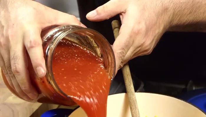Aggiungere i pomodori pelati (frullati o a pezzi) e le foglie di basilico. Salare.