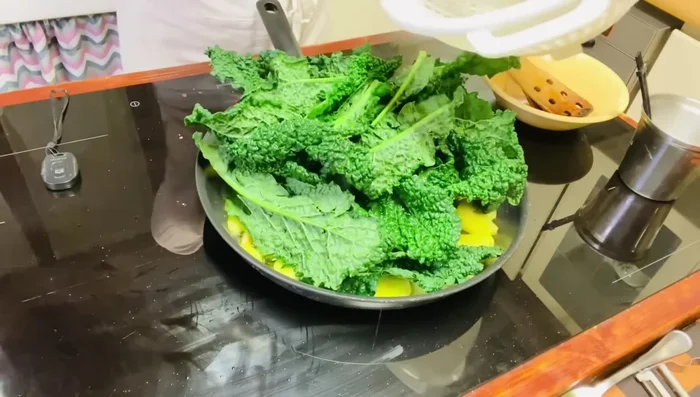 Aggiungi sale e pepe al cavolo nero. Mescola e copri la padella.