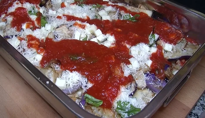 Aggiungiamo altra salsa, basilico, mozzarella e parmigiano.