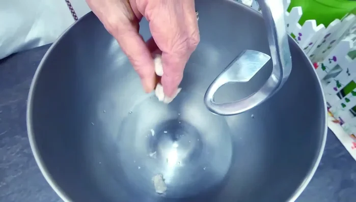 Mettere l'acqua a temperatura ambiente e il lievito sbriciolato nella planetaria e far sciogliere il lievito.