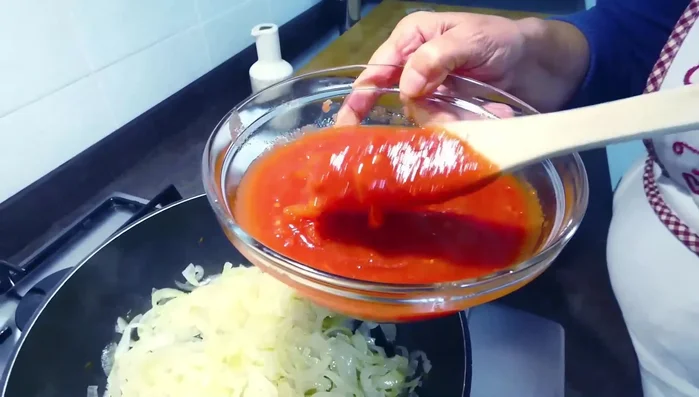 Aggiungere i pomodori pelati schiacciati a mano, salare e lasciare cuocere per circa 20 minuti.
