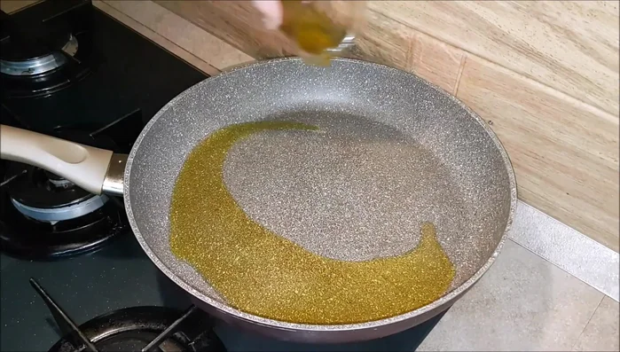 Accendete la fiamma vivace sotto la padella e aggiungete l'olio extravergine di oliva. Opzionale: fate profumare l'olio con uno spicchio d'aglio per un minuto.