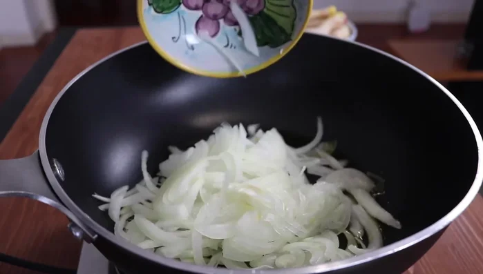 In una padella con abbondante olio d'oliva, far appassire la cipolla a fuoco basso, coprendo con un coperchio.