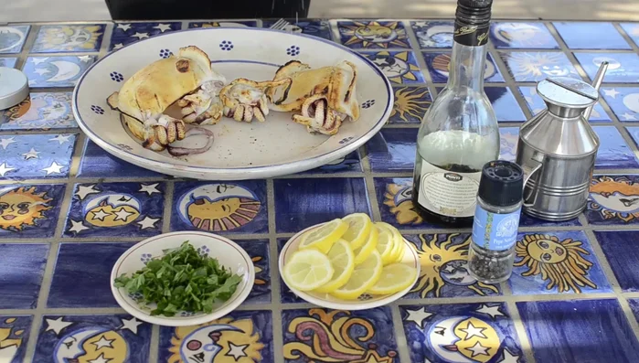 Condire le seppie con sale, pepe, prezzemolo tritato, fettine di limone, aceto balsamico e olio d'oliva.