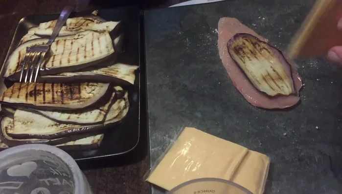 Su ogni fettina di pollo, adagiare metà di una sottiletta e una fetta di melanzana grigliata.