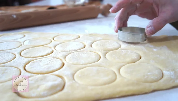 Utilizzando uno stampino per biscotti (o un bicchiere) di 5 cm di diametro, ricavare dei dischi. Sistemare i dischi su una teglia coperta da un canovaccio infarinato e coprire con un altro canovaccio. Lasciar lievitare nuovamente fino al raddoppio (222.52).