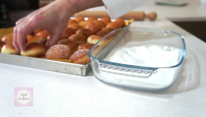 Passare i bomboloni ancora tiepidi nello zucchero semolato (346.29).