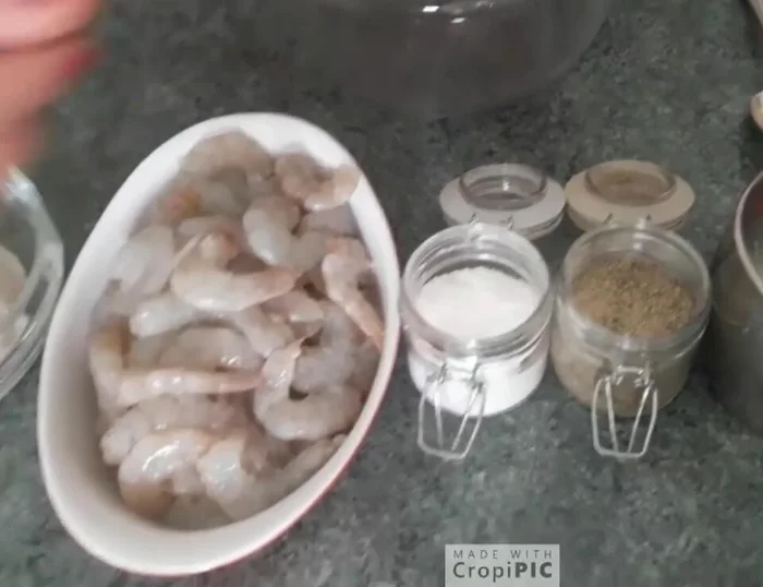 Lavare e pulire i gamberetti. Metterli in una ciotola con il succo di limone, il prezzemolo tritato e un pizzico di sale.