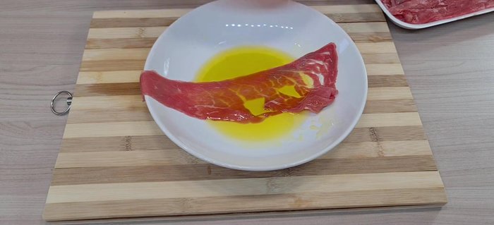 Bagnare le fettine di carne con olio.