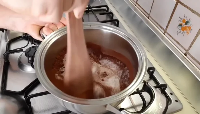 Preparare il bagnomaria al cioccolato: mescolare zucchero e cacao, aggiungere acqua e portare a ebollizione (257.72)