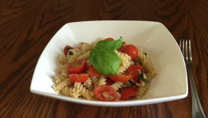 Servire caldo o freddo, guarnendo con foglie di basilico e un filo d'olio extravergine di oliva.