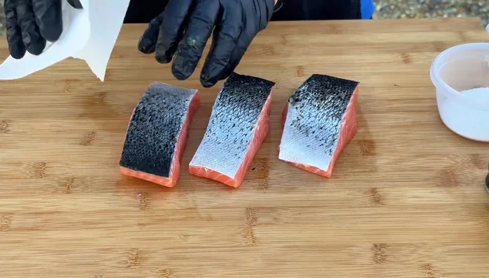 Asciugare bene ogni lato dei filetti di salmone con carta assorbente.