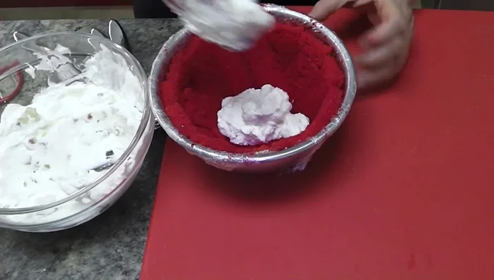 Rivestire lo stampo con uno strato di panna bianca (con i canditi).