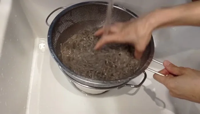 Sciacquare gli spaghetti sotto acqua fredda per interrompere la cottura. (375.919)