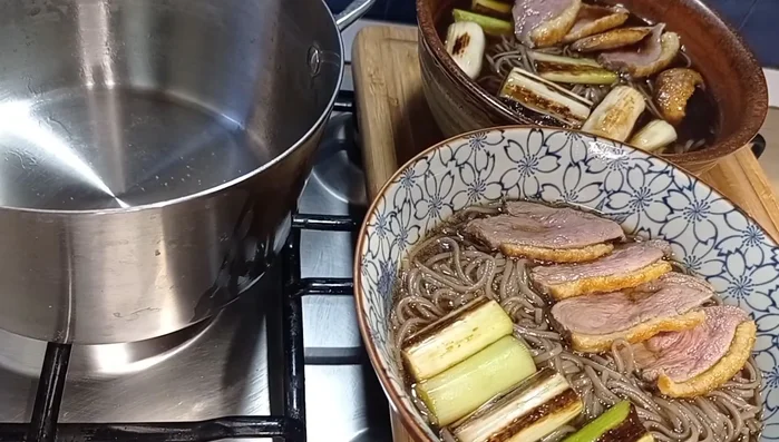 Assemblare la zuppa: In una ciotola profonda, mettere gli spaghetti, il brodo di alghe Kombu e Katsuobushi, i cipollotti, l'anatra e il Shichimi Togarashi. (444.53)