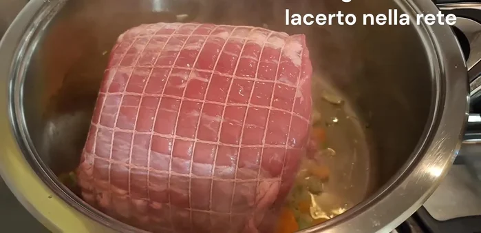 Aggiungere l'arrosto di vitello (900g), precedentemente avvolto nella rete, e sigillare la carne rigirandola da tutti i lati a fuoco vivace.