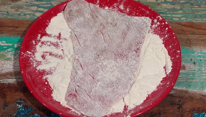 Passare le fettine di carne nella farina, scuotendo via l'eccesso per evitare che si stacchi dalle scaloppine. Assicurarsi di tamponare la carne con carta da cucina per rimuovere l'umidità in eccesso.