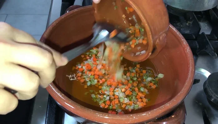 Aggiungere il sedano, la carota e la cipolla dadolati e soffriggere dolcemente.