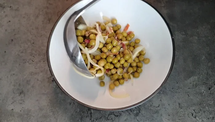 Servire i piselli pancetta e cipolla caldi. La pancetta deve risultare croccante, contrastando con la consistenza morbida dei piselli e della cipolla stufata.